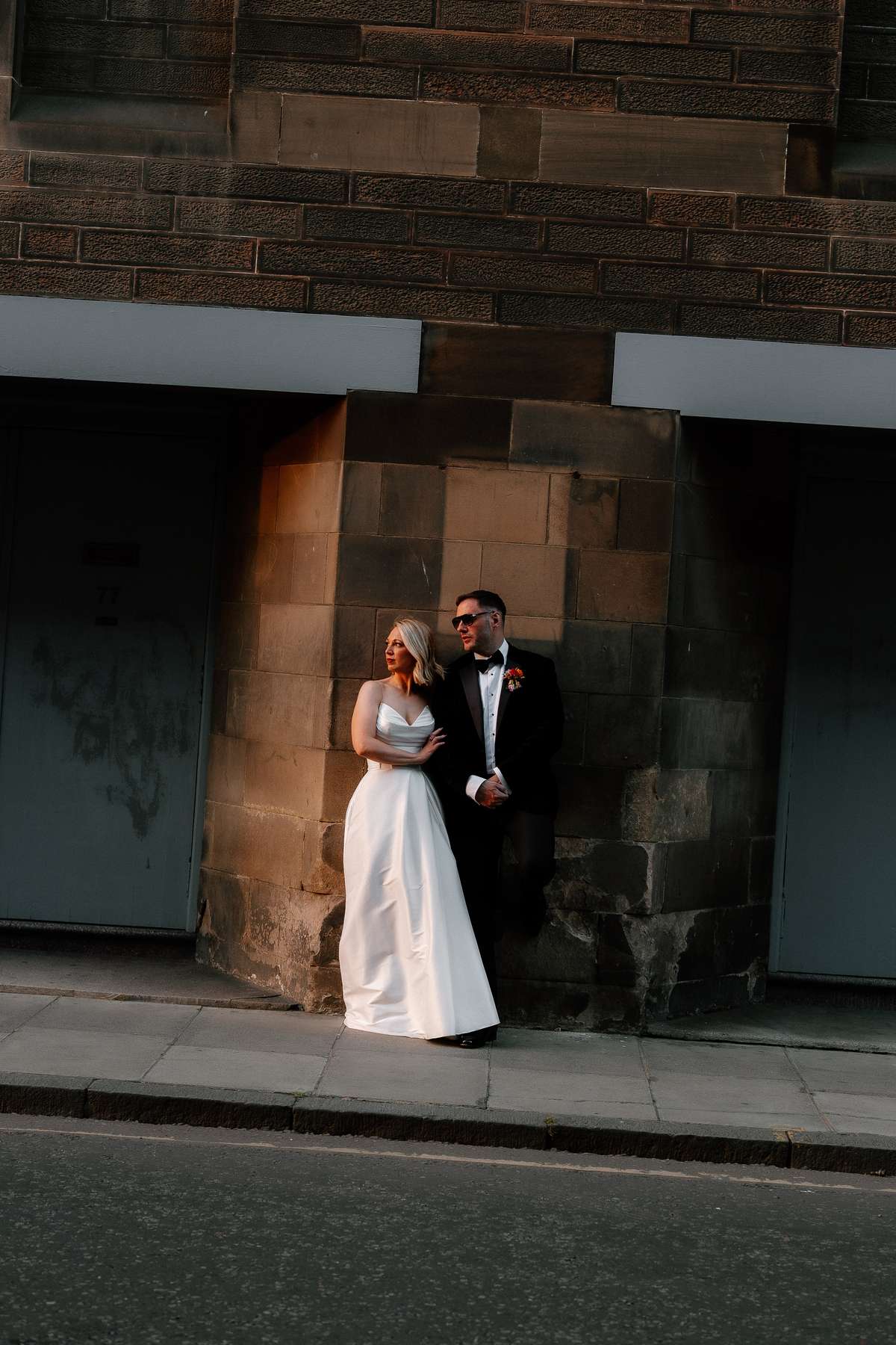 Bride Kara and groom Rory pose together on an Edinburgh street during their intimate city wedding.