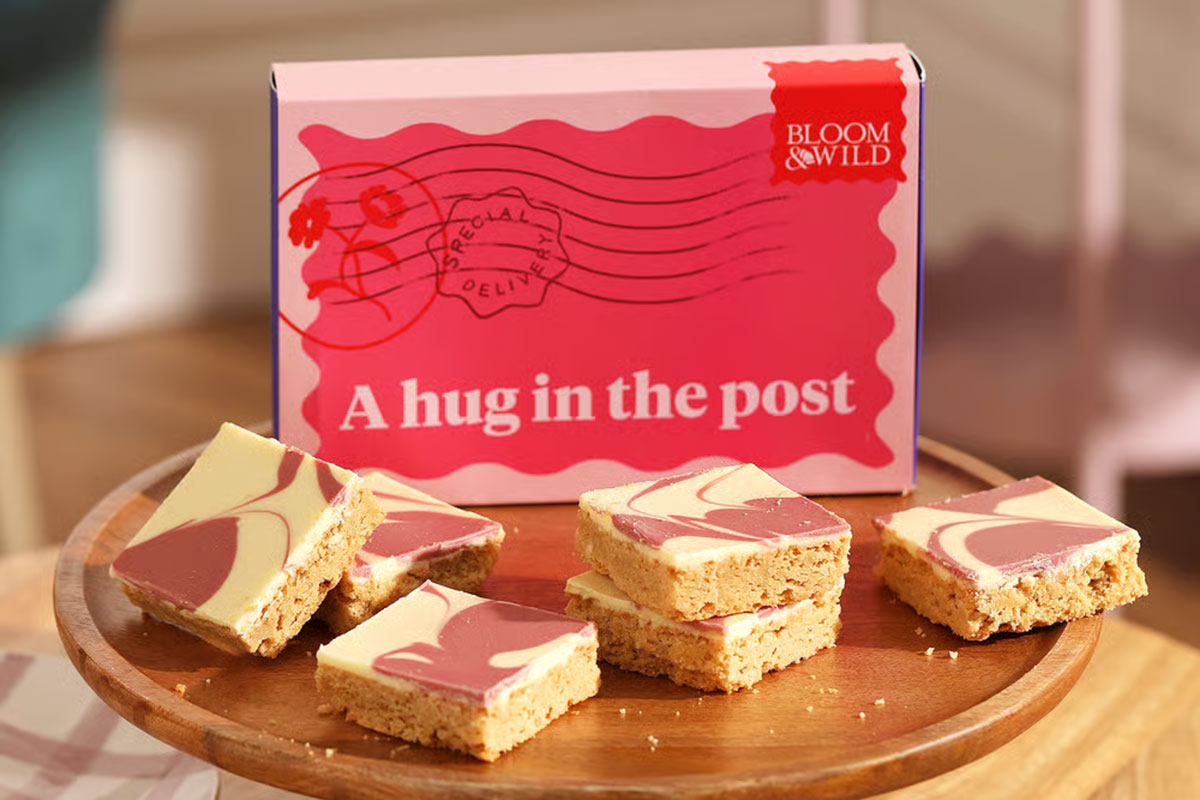 Bloom & Wild “A hug in the post” gift box with pink and white blondies on a wooden stand