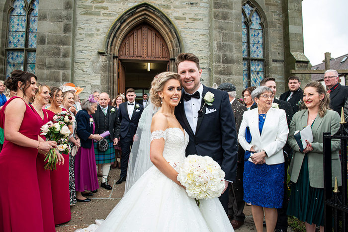 A Smiling Bride And Groom Surrounded By Guests Outside St Peters & St Andrews Church In Thurso