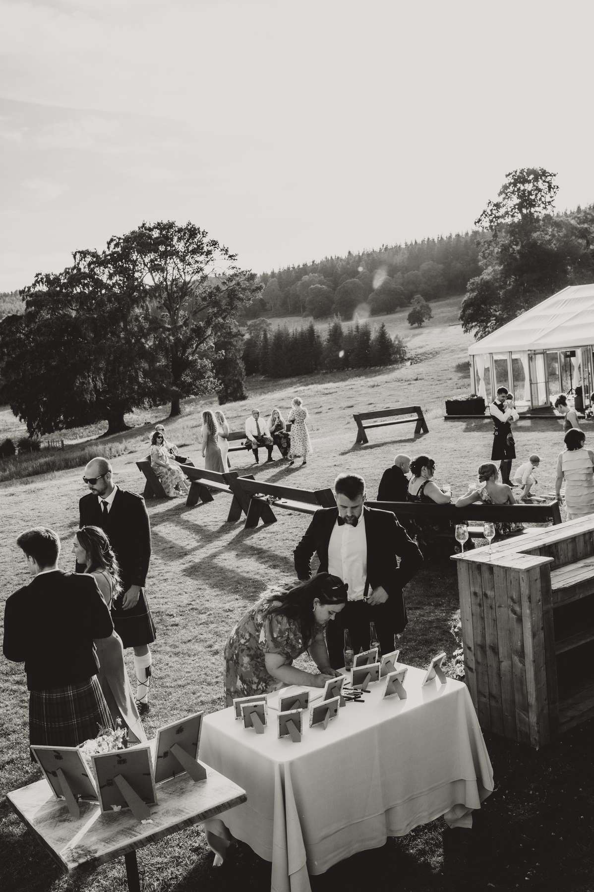 Wedding guests gather outdoors beside the marquee in the grounds of Ballogie House