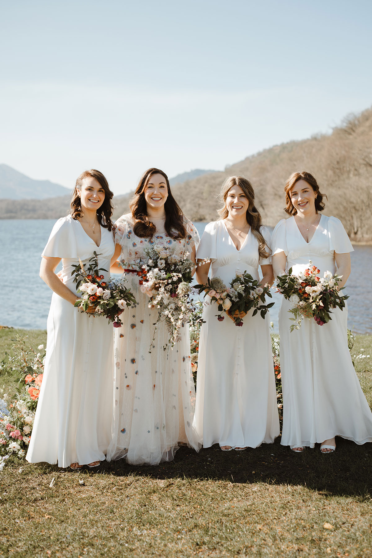 The bride with bridesmaids, in front of the loch