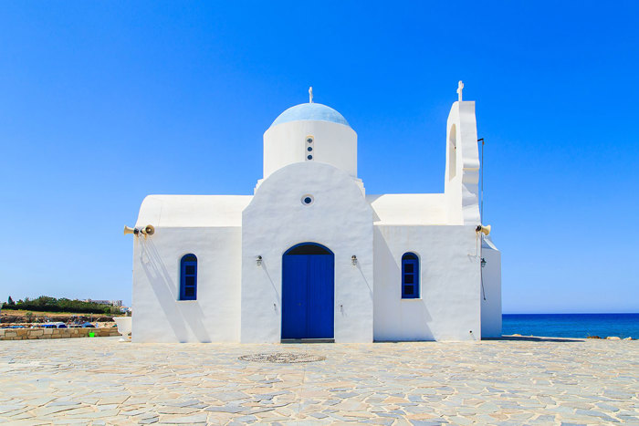   A white building with blue doors and a blue dome