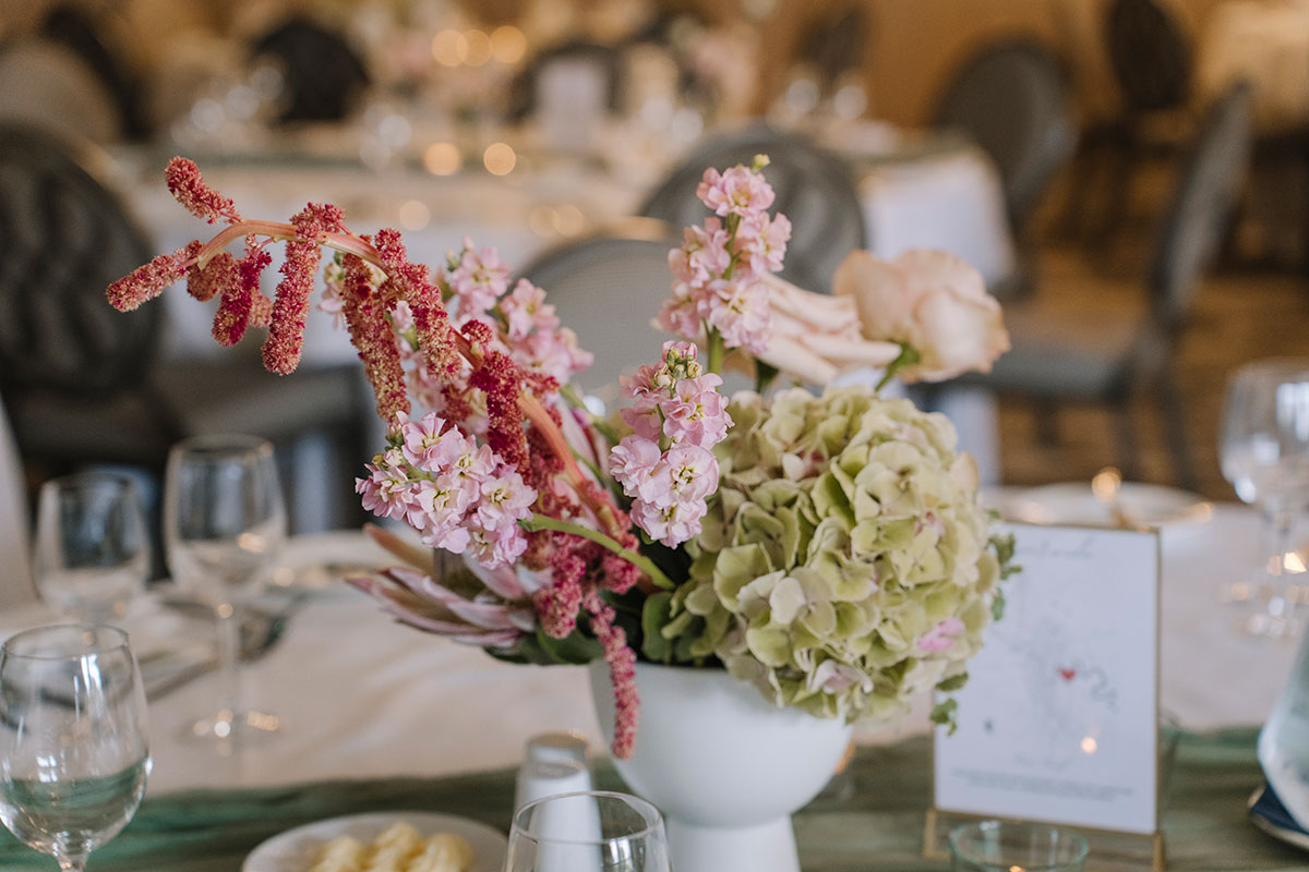 Pastel floral centrepiece with hydrangeas and soft pink flowers on a beautifully styled wedding reception table