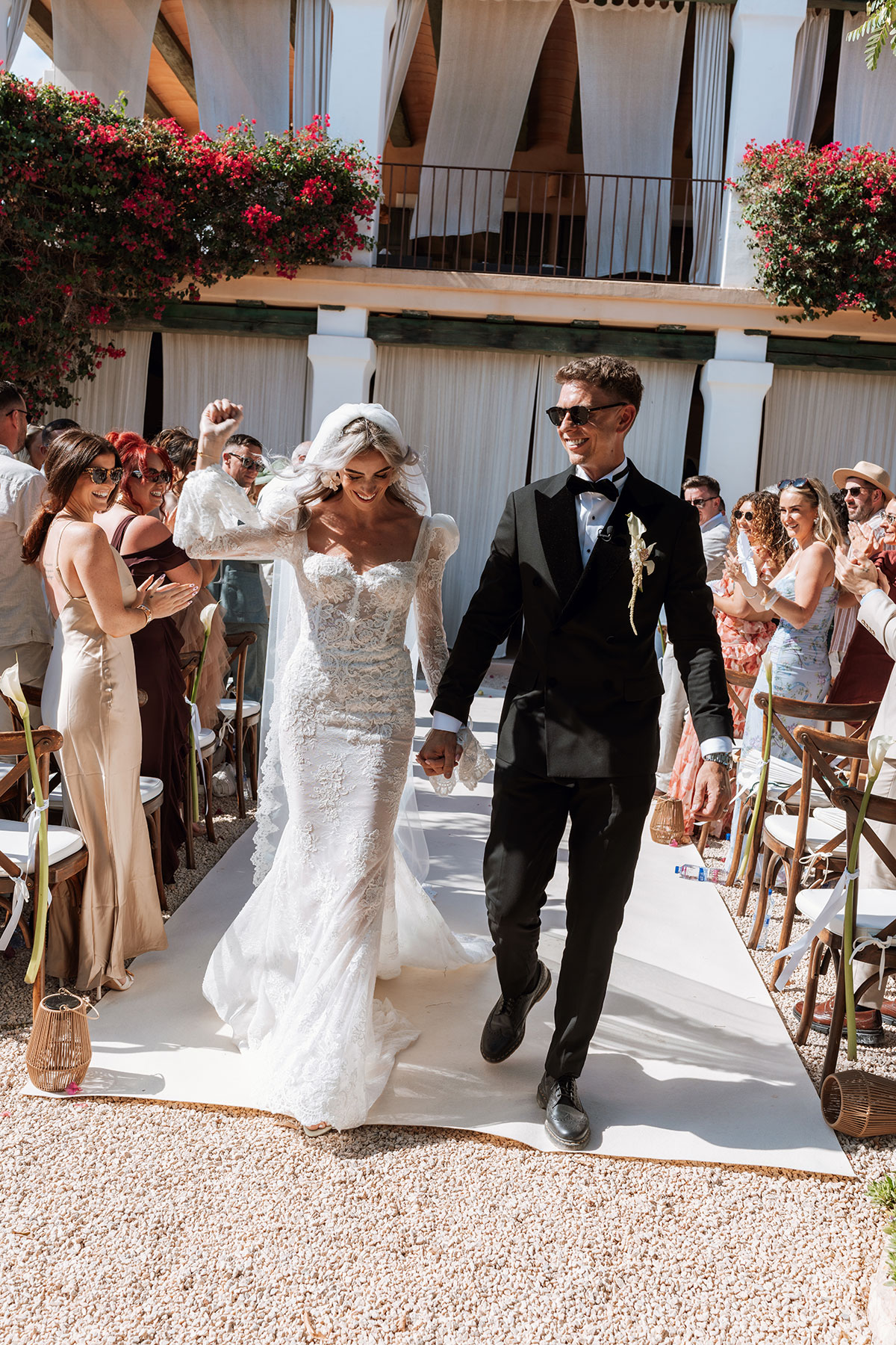 Bride and groom walking back down the aisle after outdoor Ibiza wedding ceremony at Can Rafal surrounded by guests
