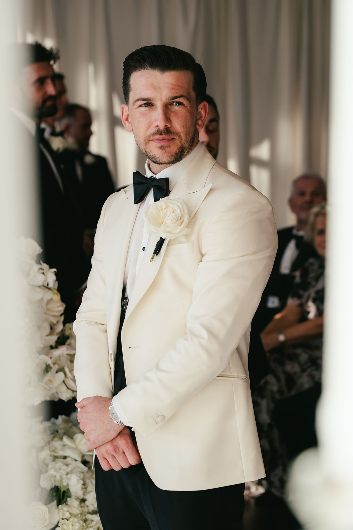 Groom in white tuxedo jacket waiting during wedding ceremony at Enterkine Country House Ayrshire