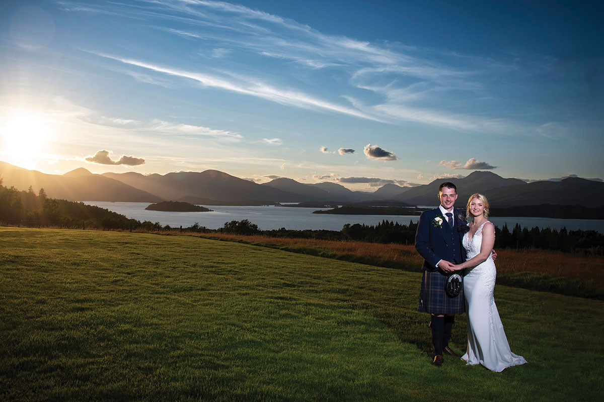 Ardoch Loch Lomond wedding venue sunset wedding photo of bride and groom outside on lawn