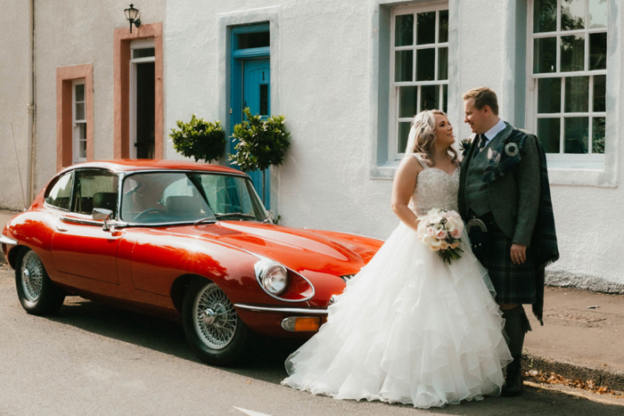 A Bride And Groom With A Red Porsche