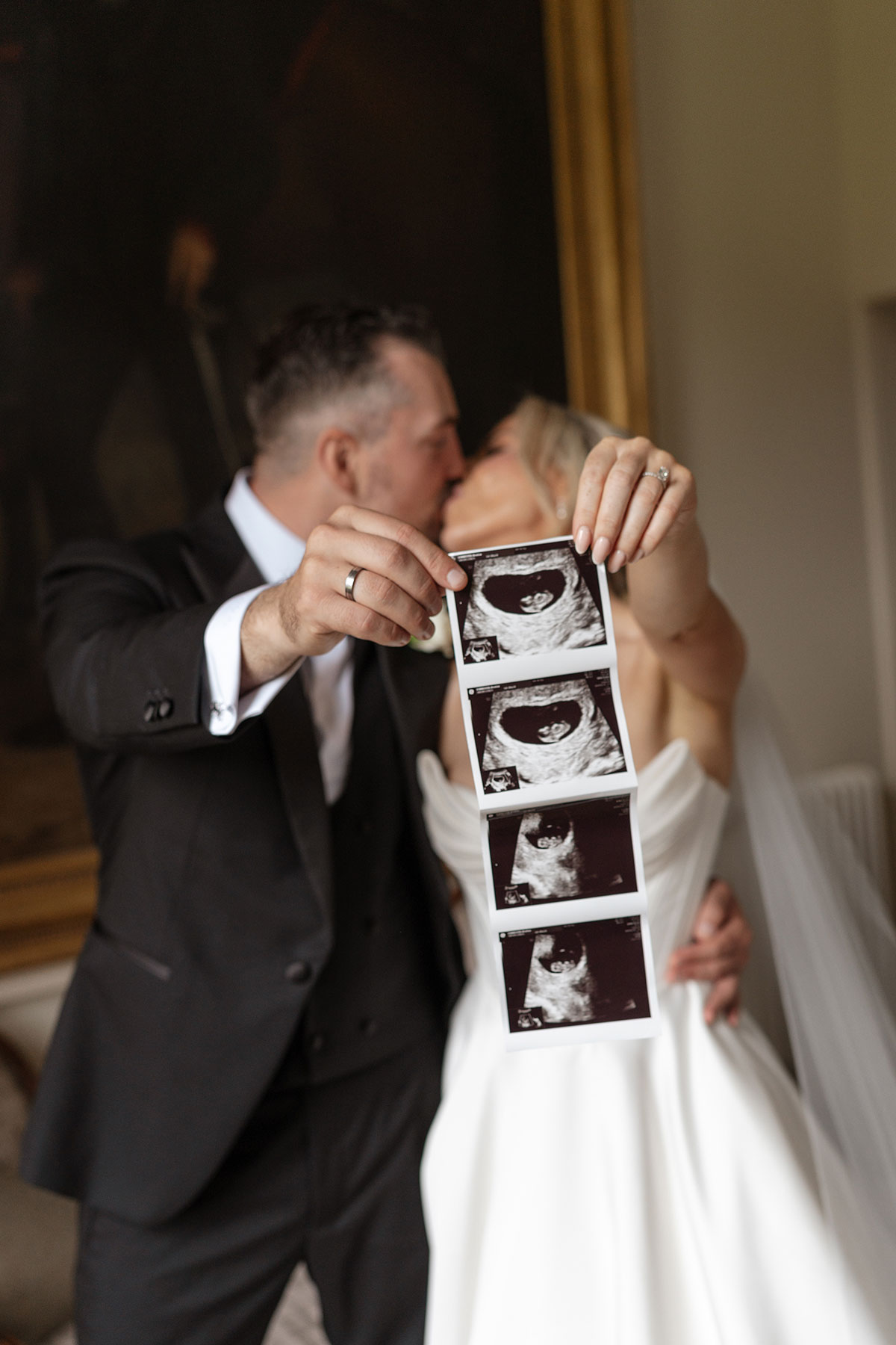 Bride and groom reveal ultrasound photos during portraits after their Boturich Castle wedding, celebrating their growing family.