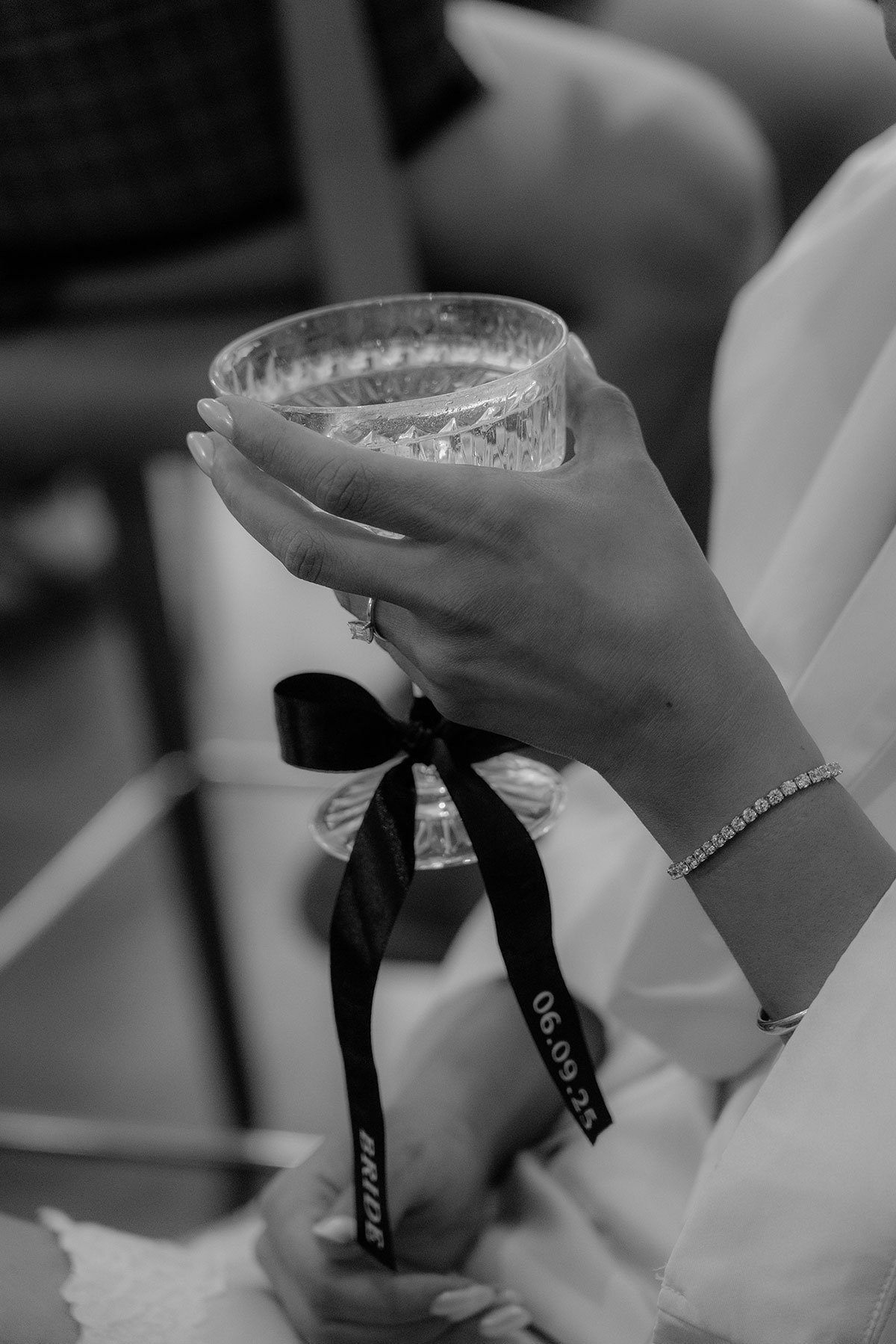 Bride holding champagne coupe with black ribbon during Brisbane House Hotel wedding preparations