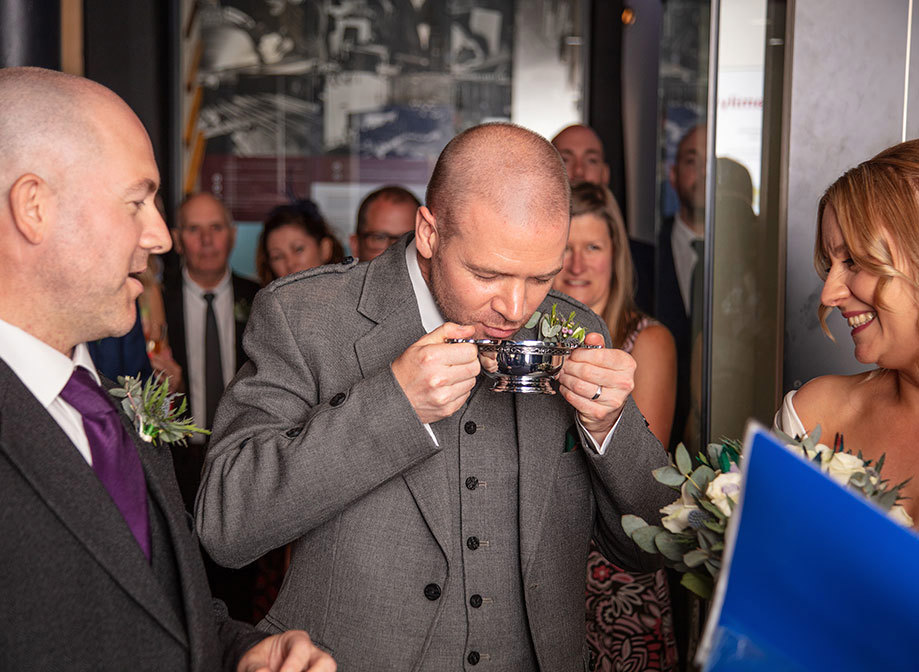 A man drinking from a silver quaich