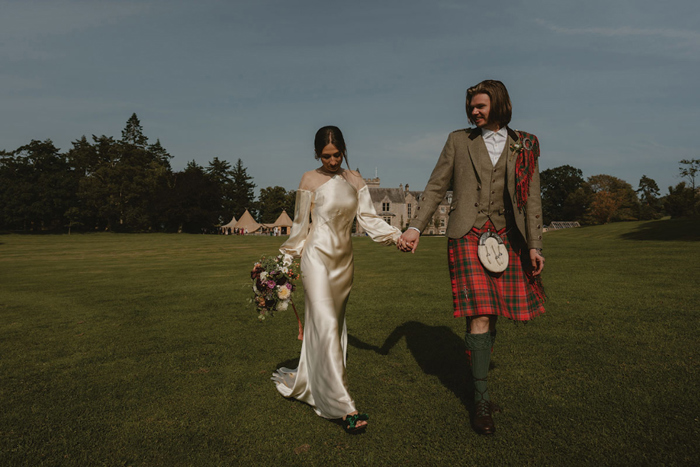 A Bride And Groom Walking In The Grounds At Hartree Estates