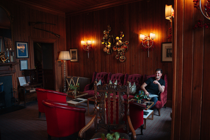 Groom sits in a cosy room in The Torriden Hotel