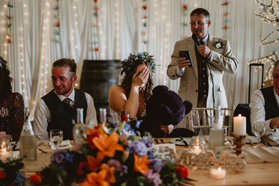 Bride covers her face during her dad's speech