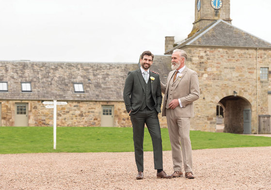 two men in Slater Menswear suits standing outside Rosebery Steading
