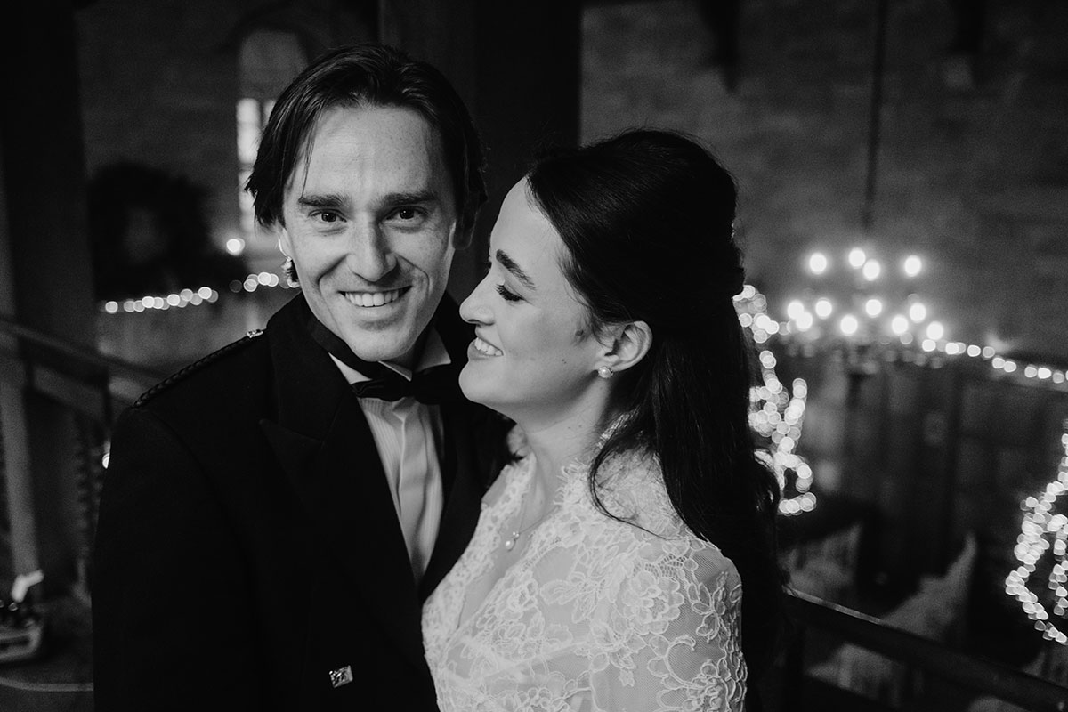 a bride and groom pose for a photo with soft illuminated lighting in background.