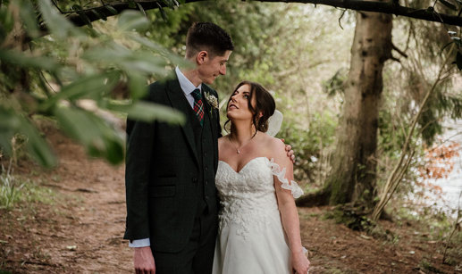 bride and groom looking at each other in a woodland