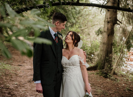 bride and groom looking at each other in a woodland