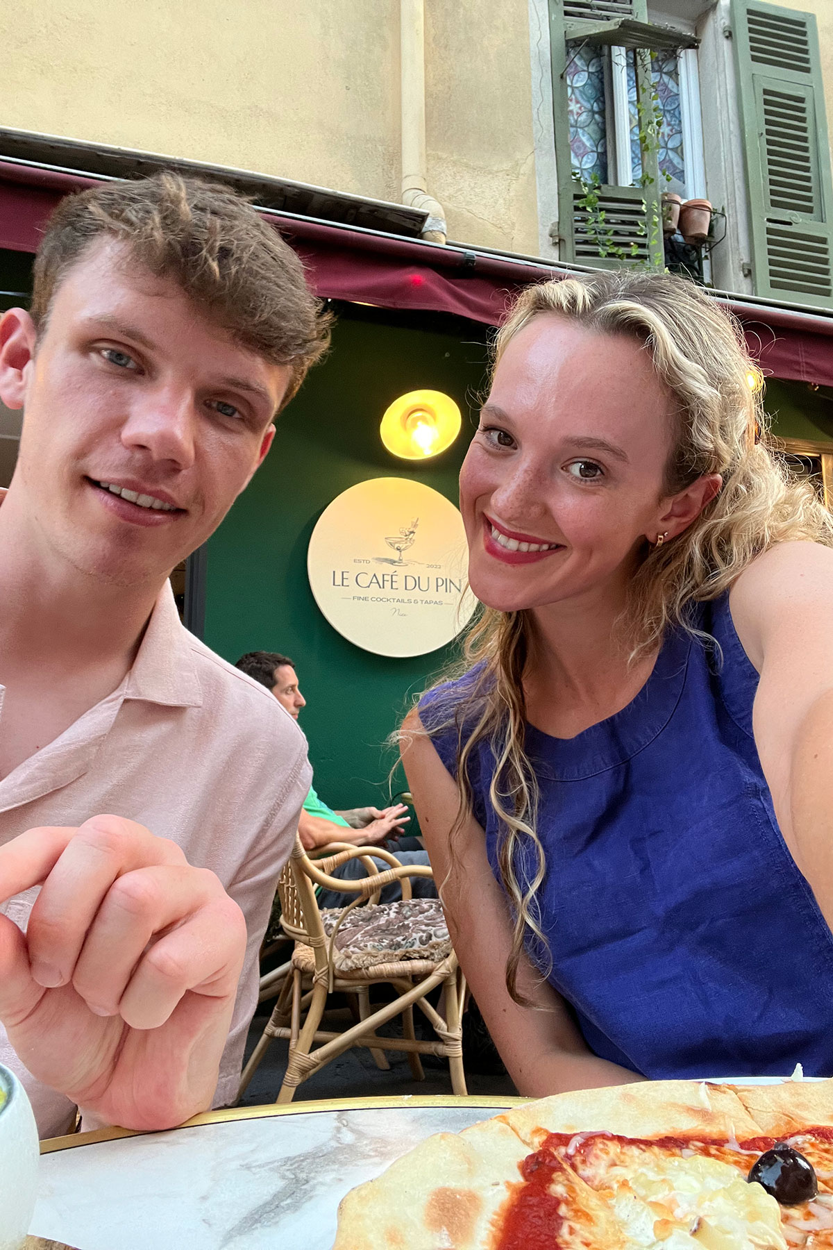 a couple posing for a photo outside Le Cafe du Pin