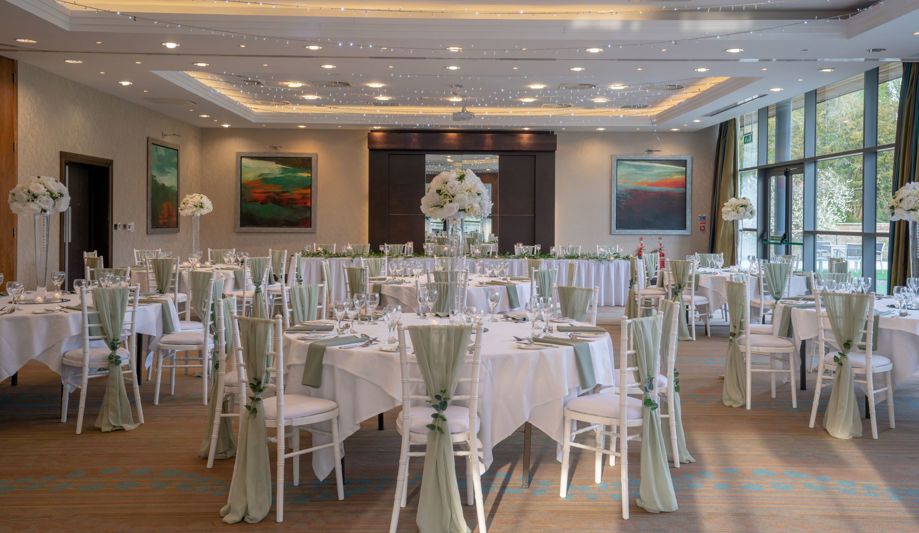 room set up for wedding dinner with Chiavari chairs and sage green covers