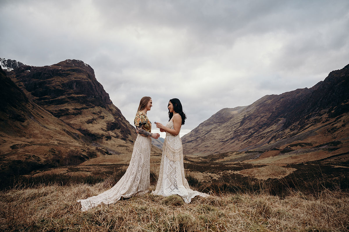 Couple standing together in the Glencoe mountains during an outdoor Scottish elopement ceremony setup.