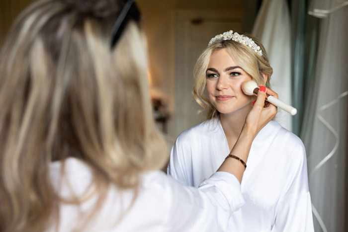 Makeup artist putting product on the bride