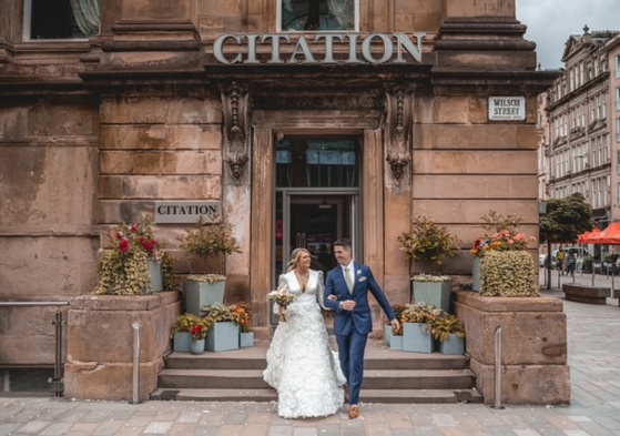 couple walking down steps of Citation wedding venue in Glasgow after getting married 