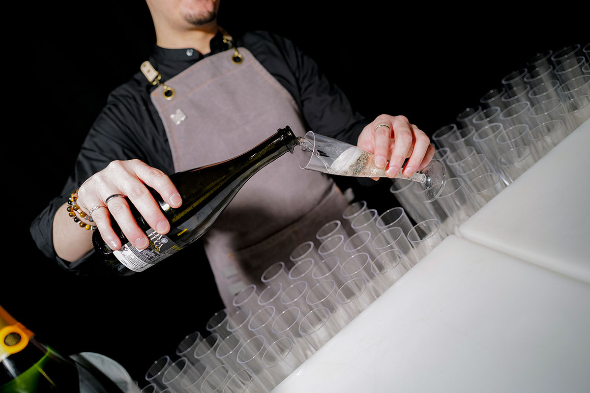 Member of bar staff pouring a glass of prosecco for visitors at The Scottish Wedding Show.
