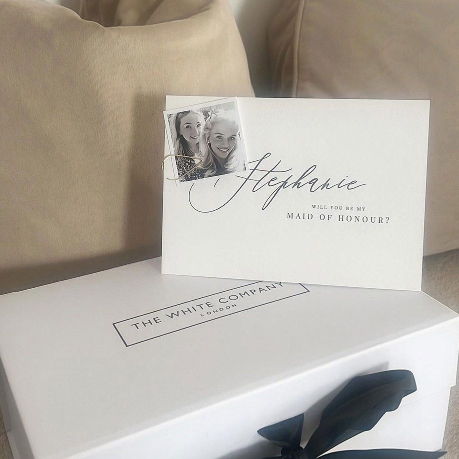 A white box with a black ribbon and a card on it