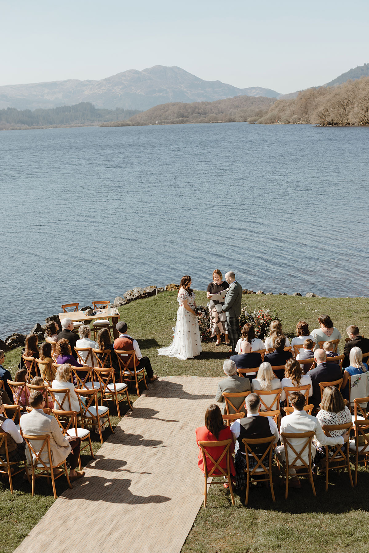 Ceremony by the loch as seated guests watch