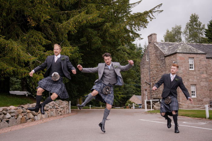 Three Men In Kilts Jumping And Clicking Heels Together