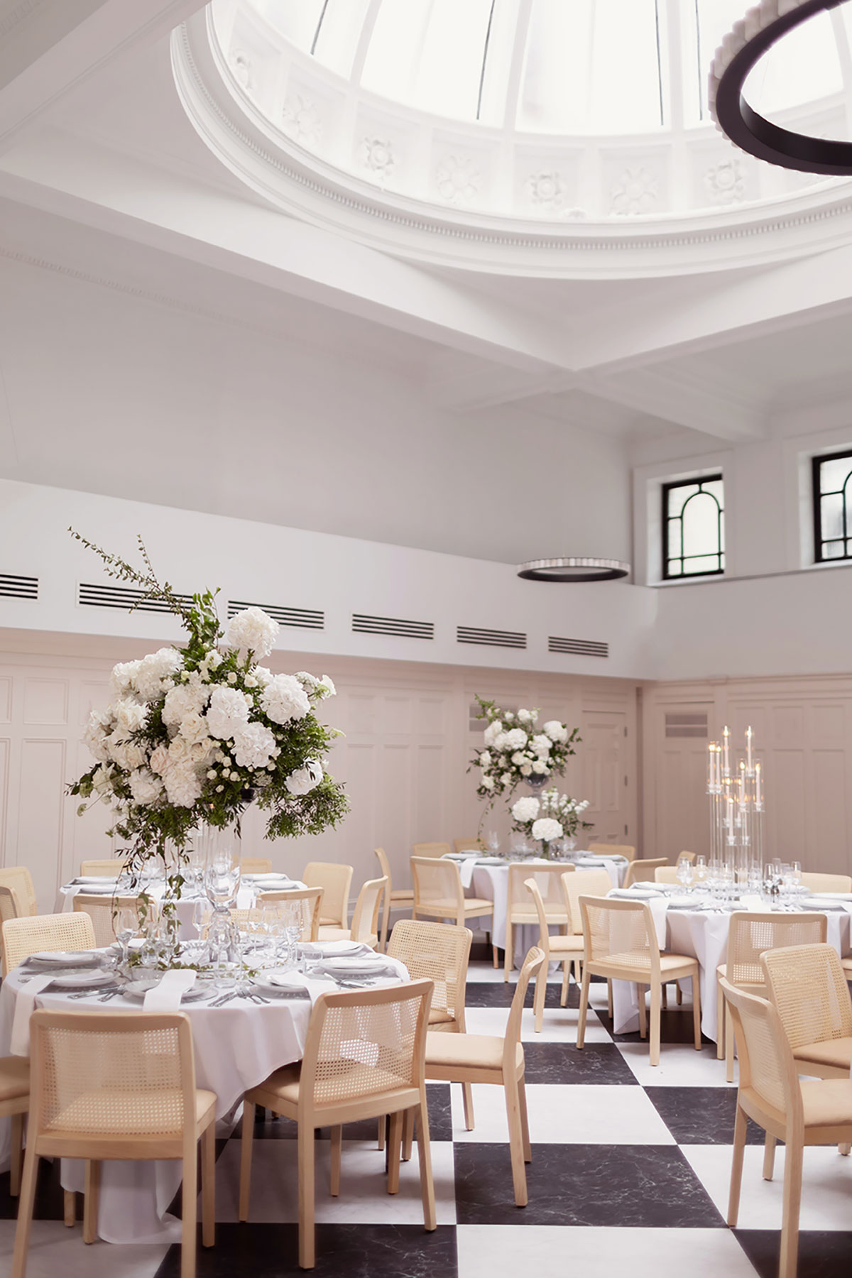 Reception setup inside The Collector’s Hall, featuring monochrome flooring, domed ceiling, and white floral centrepieces