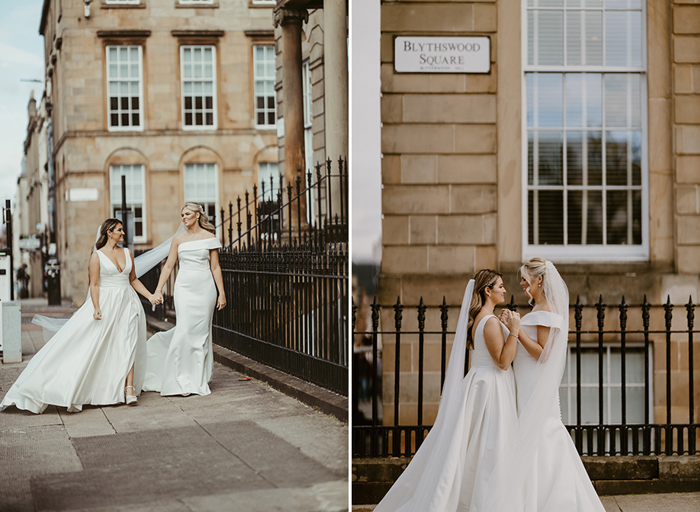 Two brides walking and posing on the street at Blythswood Square in Glasgow with buildings and railings in background
