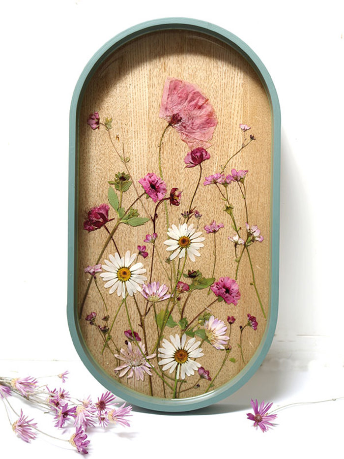 oval wooden serving tray with pressed flowers in the base