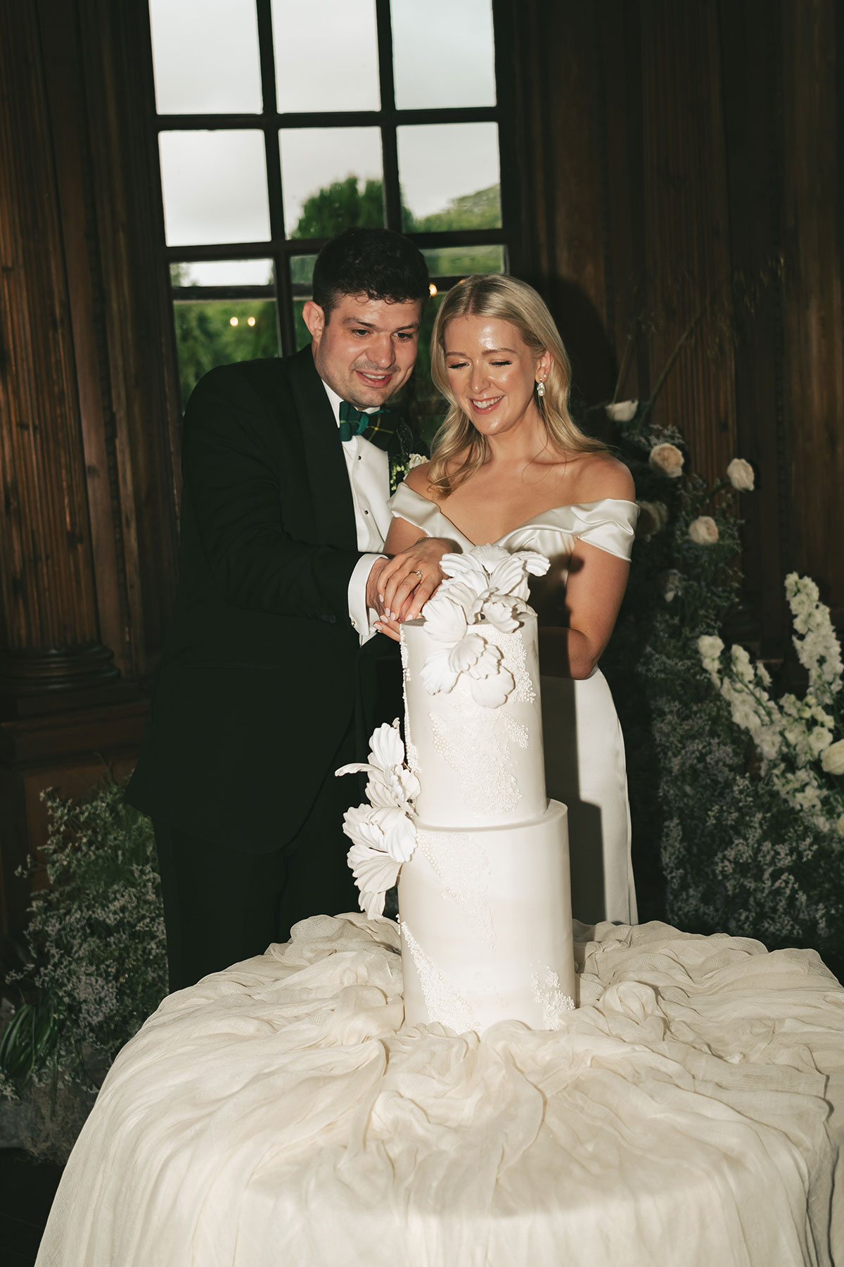 Bride and groom cutting elegant wafer paper wedding cake at Gilmerton House reception