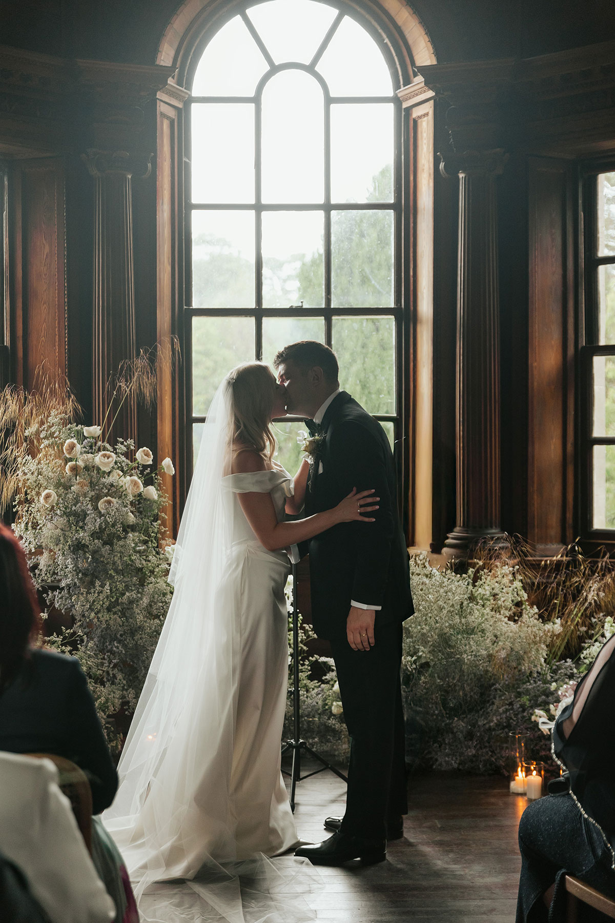 Bride and groom kissing during candlelit indoor ceremony at Gilmerton House East Lothian