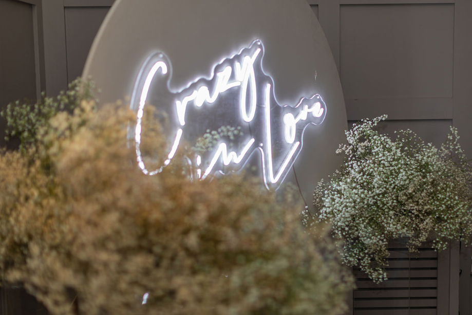 Wedding decor showing 'crazy in love' sign and white foliage