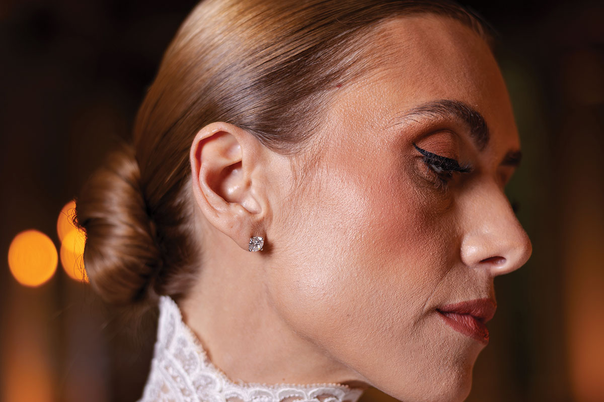 Close-up of model wearing round brilliant lab-grown diamond stud earrings in 18ct white gold setting