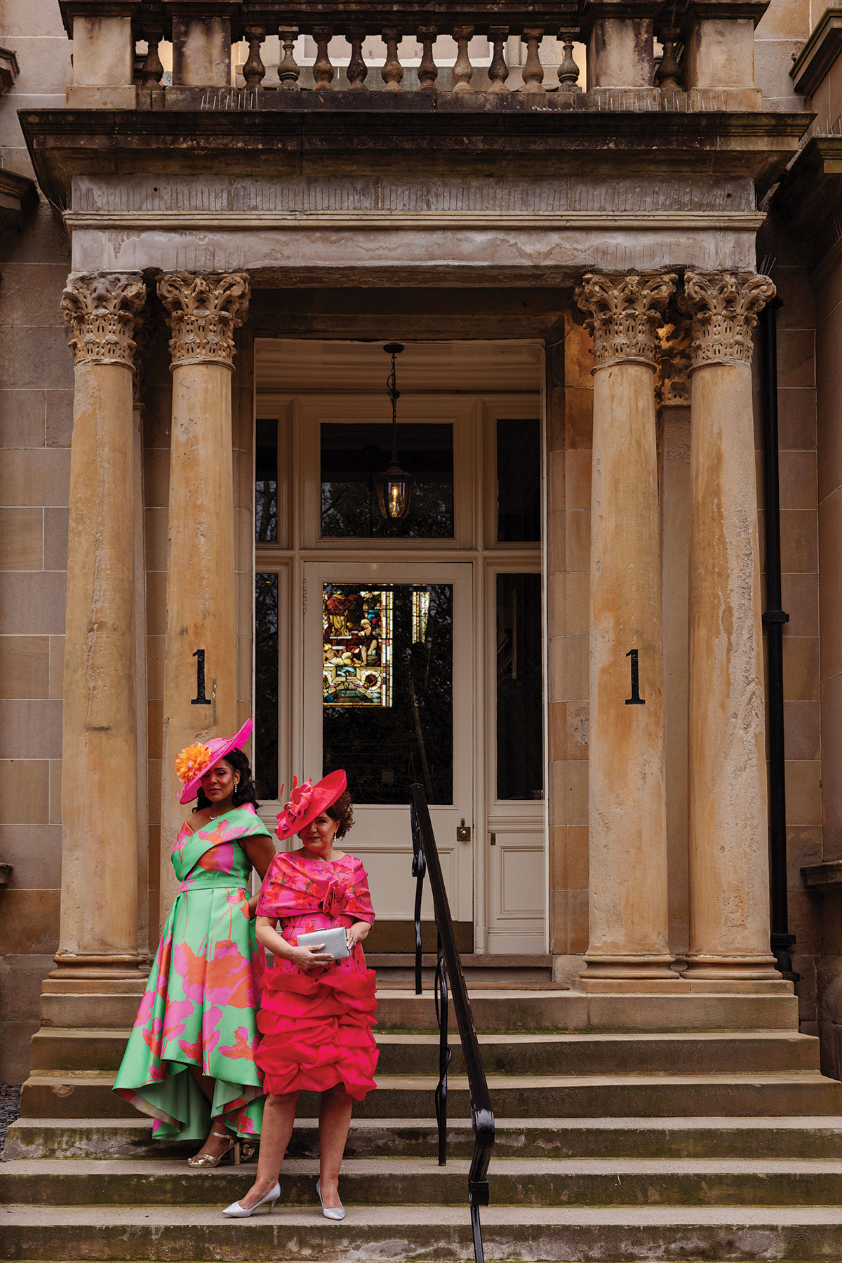 Colourful mother of the bride outfits with hats by Frox of Falkirk outside One Devonshire Gardens wedding venue in Glasgow