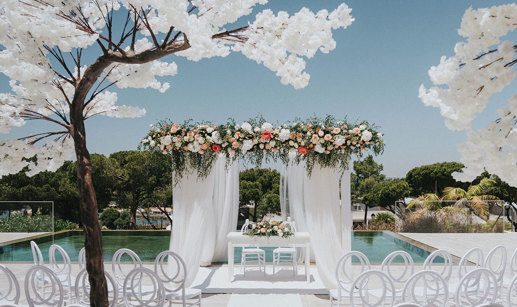 a white wedding ceremony set up outside with blossom trees at Quinta do Lago Portugal