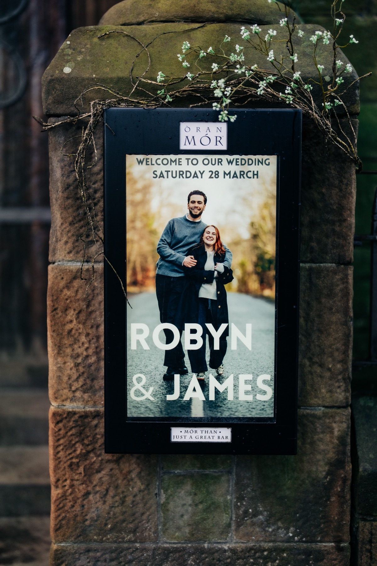 Personalised wedding welcome sign for Robyn and James displayed outside Òran Mór in Glasgow, featuring their photograph and wedding date of 28th March 2026.
