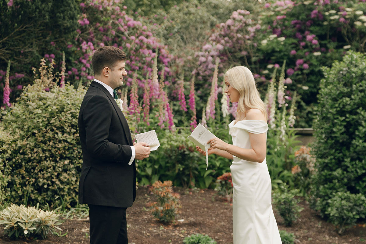 Bride and groom reading private vows in garden at Gilmerton House East Lothian wedding