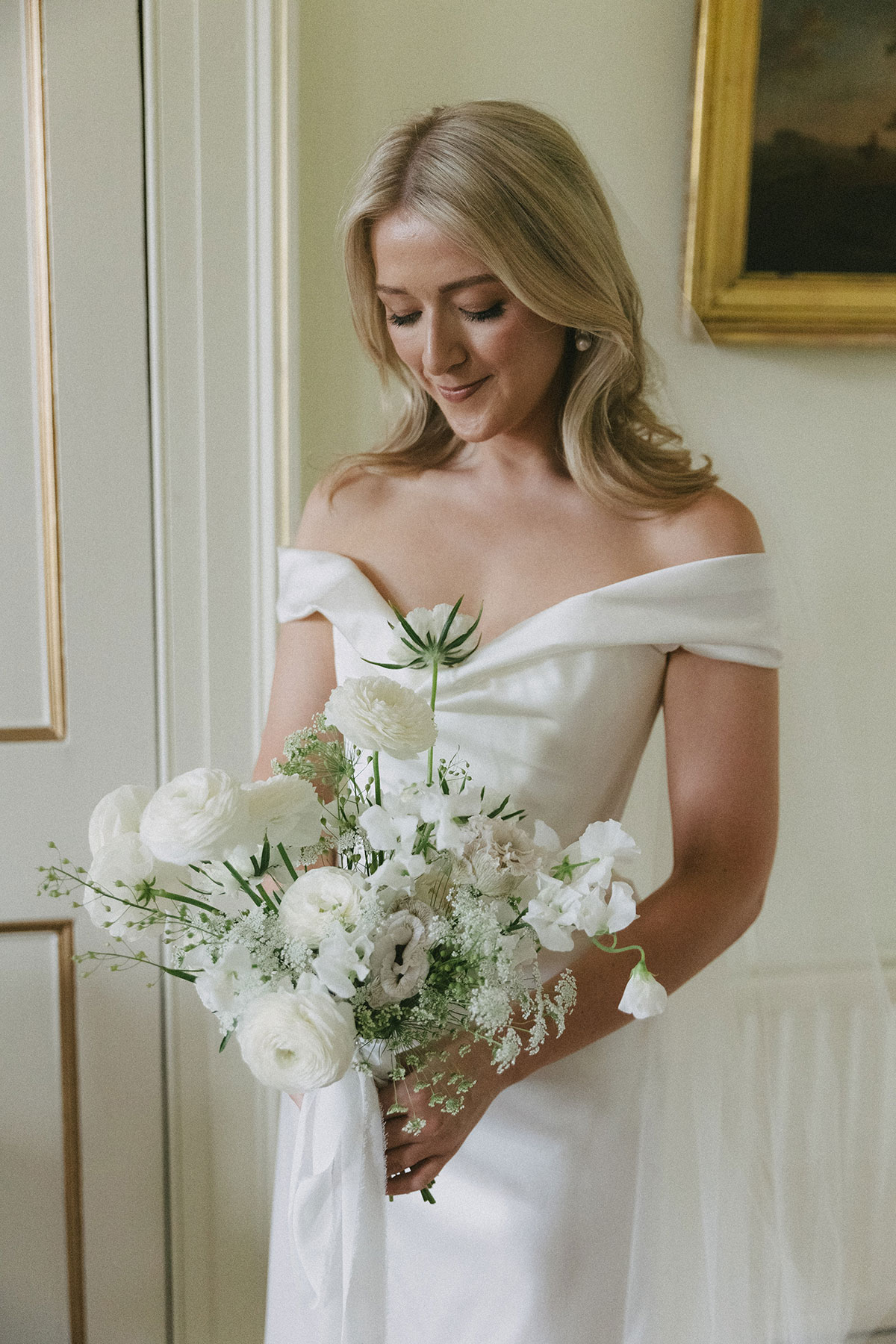 Bride in Vivienne Westwood Nova Cora wedding dress holding white floral bouquet at Gilmerton House