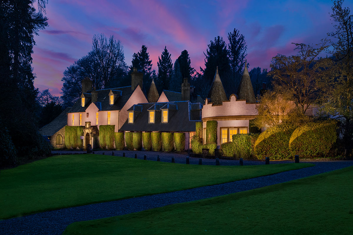 Thackray House exterior and gardens illuminated at dusk beneath a colourful evening sky.