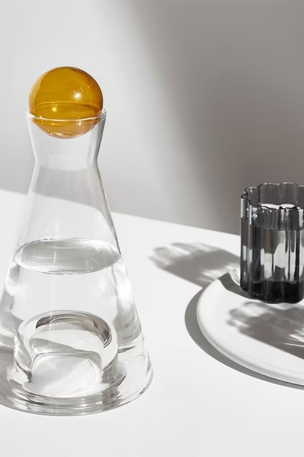 Vice Versa glass carafe with amber stopper beside a drinking glass, a stylish homeware wedding gift idea for newlyweds
