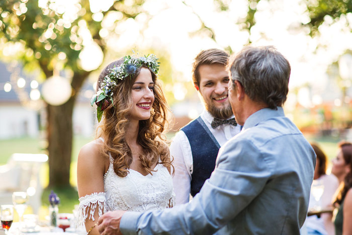 Stock image showing bride and groom with older man