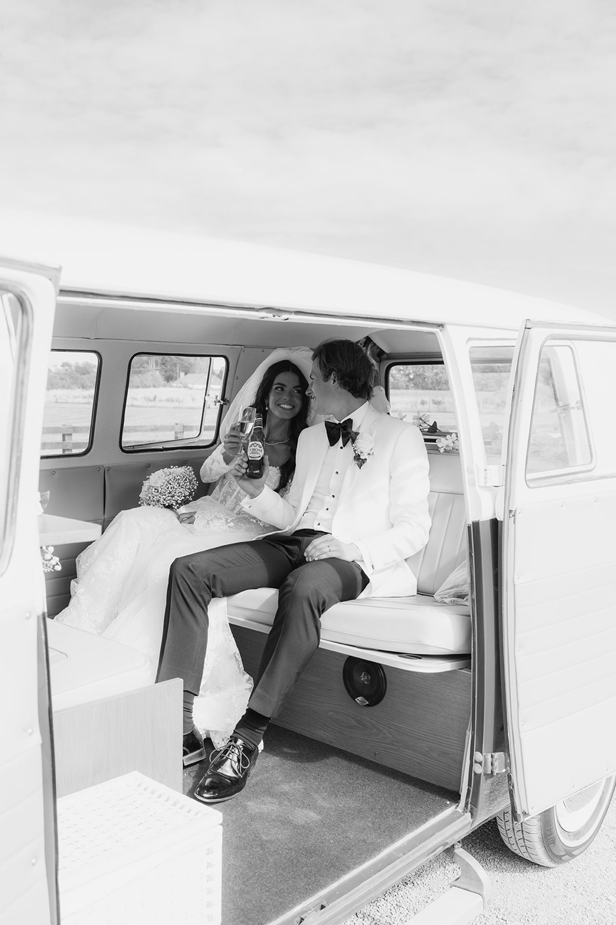 Bride and groom relaxing in a vintage VW camper van after their Scottish wedding ceremony
