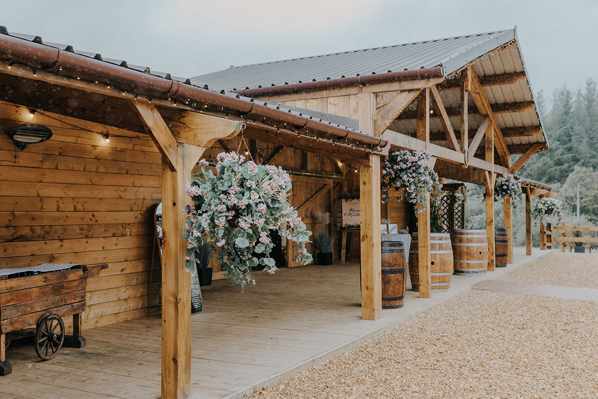 Rustic barn exterior at Eden Leisure Village decorated with floral arrangements for an outdoor wedding reception.
