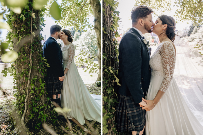 Bride and groom kiss under tree
