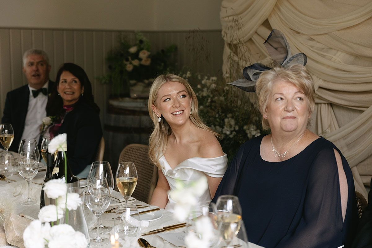 Bride smiling during wedding speeches at Gilmerton House reception with guests
