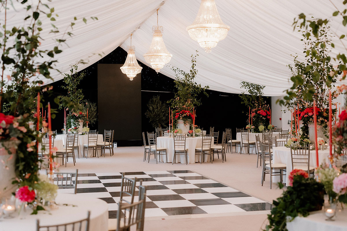 Elegant marquee reception at Mar Hall featuring chandeliers, greenery and a black-and-white dancefloor.